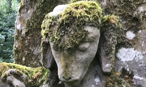 Moss covers the goat-headed statue found in an English country garden.