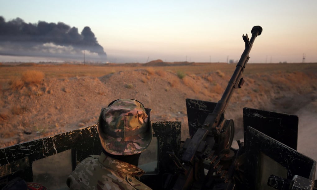 Smoke billows in the background as Iraqi pro-government forces advance towards the city of Fallujah. 