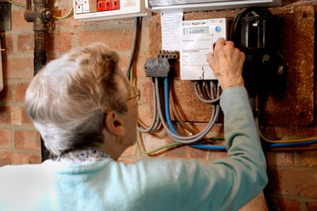 Elderly woman using a prepayment electric meter.