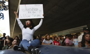 Jasmine Malone, 23, holds a sign at a vigil held for Wilson on Monday.