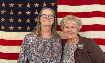 Carla McFarland (left) and Cookie Wozniak (right) standing in front of a US flag in Rome, Georgia.