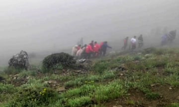 Rescuers recovering bodies at the site of the helicopter crash