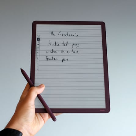 A hand holds a stylus near a Kindle Scribe displaying handwritten notes on a lined page