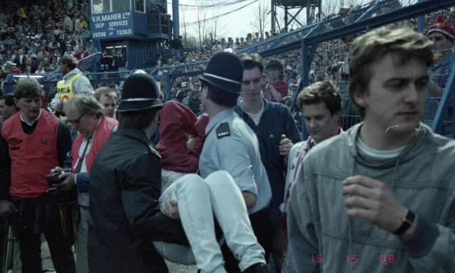 An injured victim is carried away by the police on the terrace at Hillsborough during the 1989 FA Cup semi final. Photograph: PA