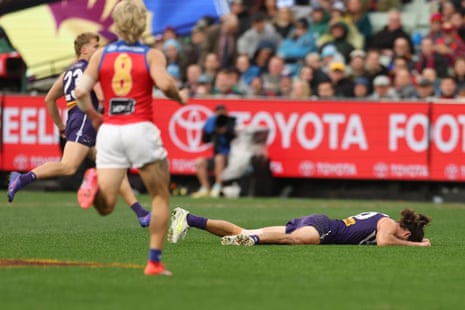 Alex Pearce falls to the turf with a leg issue