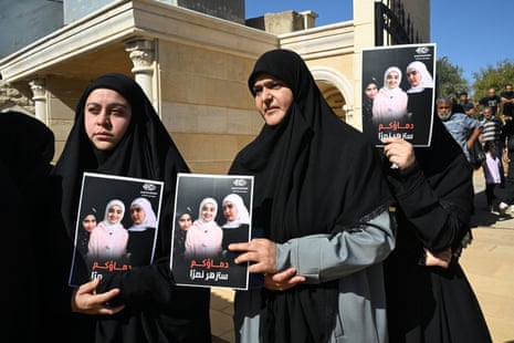 Women hold pictures of the three children killed by Israeli military action in Lebanon.