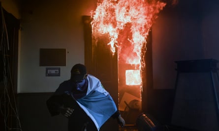 A demonstrator runs after setting an office on fire in the Congress building.