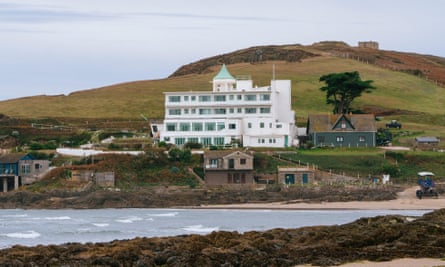 Burgh Island Hotel at the foot of a hill and the with sea in the foreground