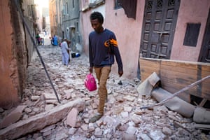 A man walks through the rubble in an alleyway in Marrakech.