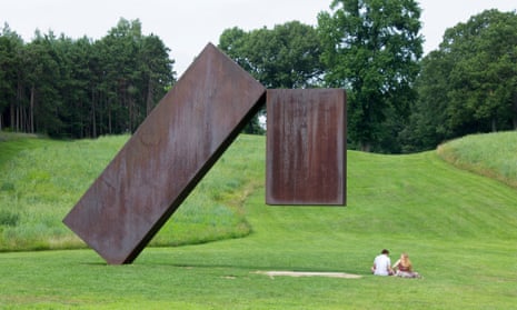 two large blocks of dark metal, one leaning and one upright, on green grass