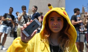 A gamer dressed up like a Pokemon shows her mobile phone.