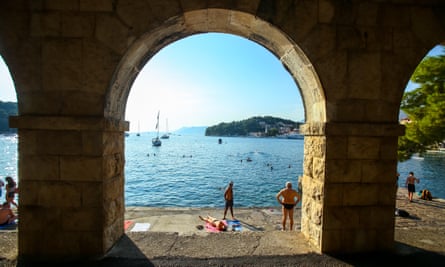 sea through old arches and people sunbathing