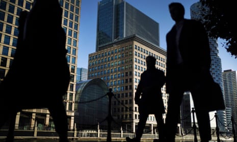 Office workers and commuters walking through Canary Wharf in London.