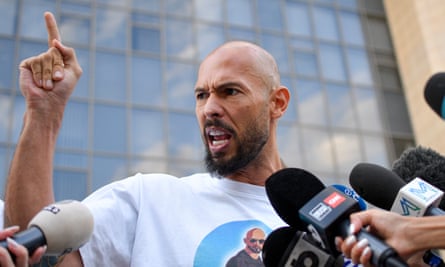 Andrew Tate angrily gesticulates in front of microphones