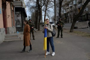 Woman holds Ukrainian flag near soldiers