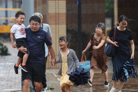 People brave the heavy wind and rain as they cross a street in Hong Kong