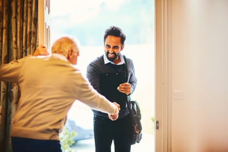Senior man welcoming a healthcare worker - Home visitYoung male community healthcare worker being welcomed by a senior man at his home