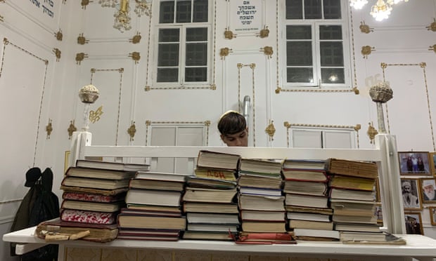 Benyamin Badalov, 15, reads the evening prayer on the first night of Hanukah at the main synagogue in Bukhara.