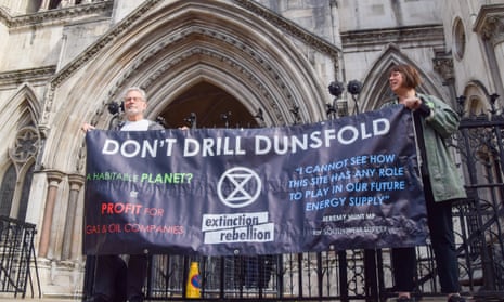 Climate protesters hold a banner outside the Royal Courts of Justice
