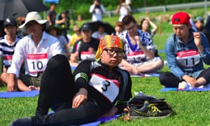 people lie or sit on the grass in a seoul park