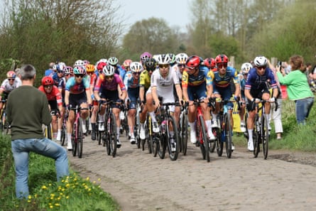 Lotte Kopecky, centre, leads the pack of riders over a cobbled sector.