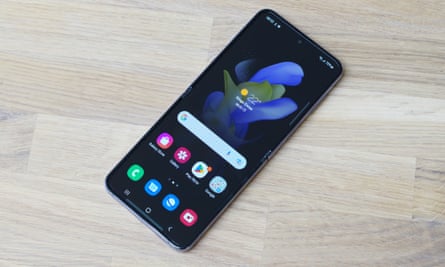 Samsung Galaxy Z Flip 4 مفتوح تمامًا ، مما يجعل الشاشة الرئيسية مستلقية على الطاولة.