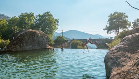Boys jumping into a picturesque river on sunny day