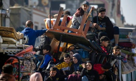 People sitting on vehicles with their belongings.