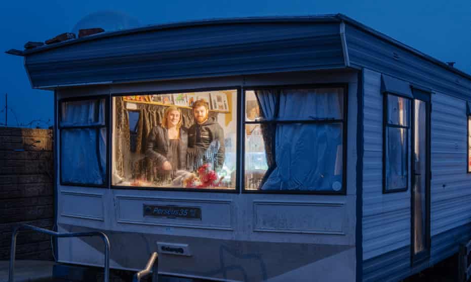 Charlotte Williams and Tom Evans in their caravan, where they are bringing up their baby, Twm. They can’t afford a property anywhere in the area.