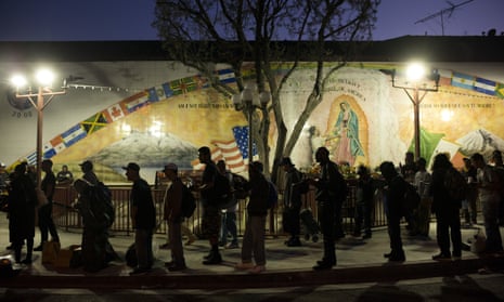 Homeless people wait in line for a meal served by a community organization outside Our Lady Queen of Angels Catholic church in Los Angeles.