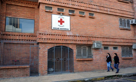 Women walk past a maternity home for sexually abused and pregnant girls and teenagers where a 10-year-old who was raped by her stepfather and is now five months pregnant is taken care of in Asuncion.