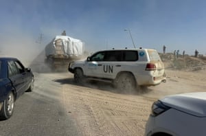 Trucks driving along a dusty road
