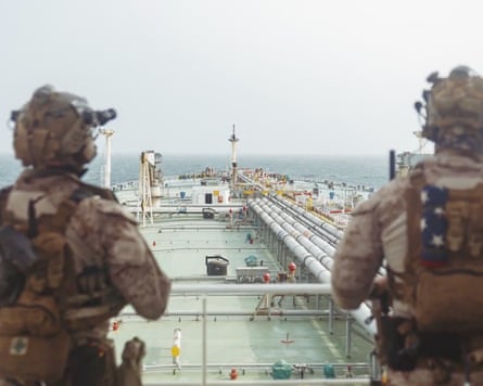 Two Marines on an upper deck looking down on the rest of the ship
