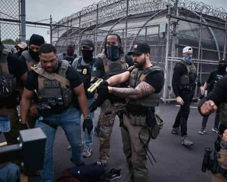 A federal agent threatens to Taser protesters outside a detention facility in Newark, New Jersey, 13 June 2025.