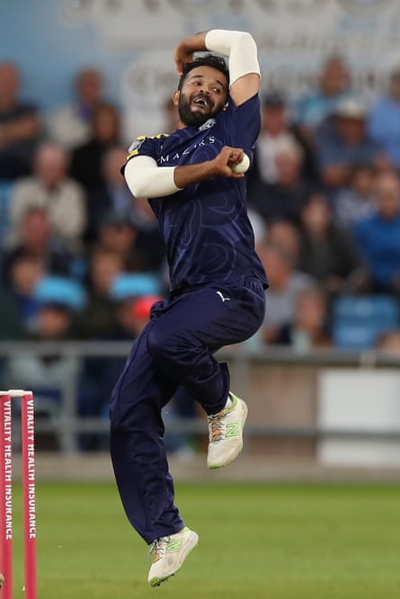 Rafiq bowling at a cricket match, wearing a dark blue kit.