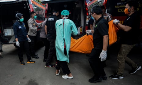 Police officers transfer a body bag of the victim of a prison fire in Tangerang, Indonesia.