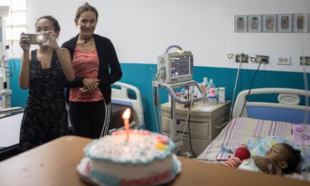 María and Alexandra smile as doctors sing happy birthday to Luciannys on her first birthday