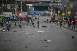 People run after clashes erupted during a protest against fuel price rises and to demand that Haitian prime minister Ariel Henry step down in Port-au-Prince