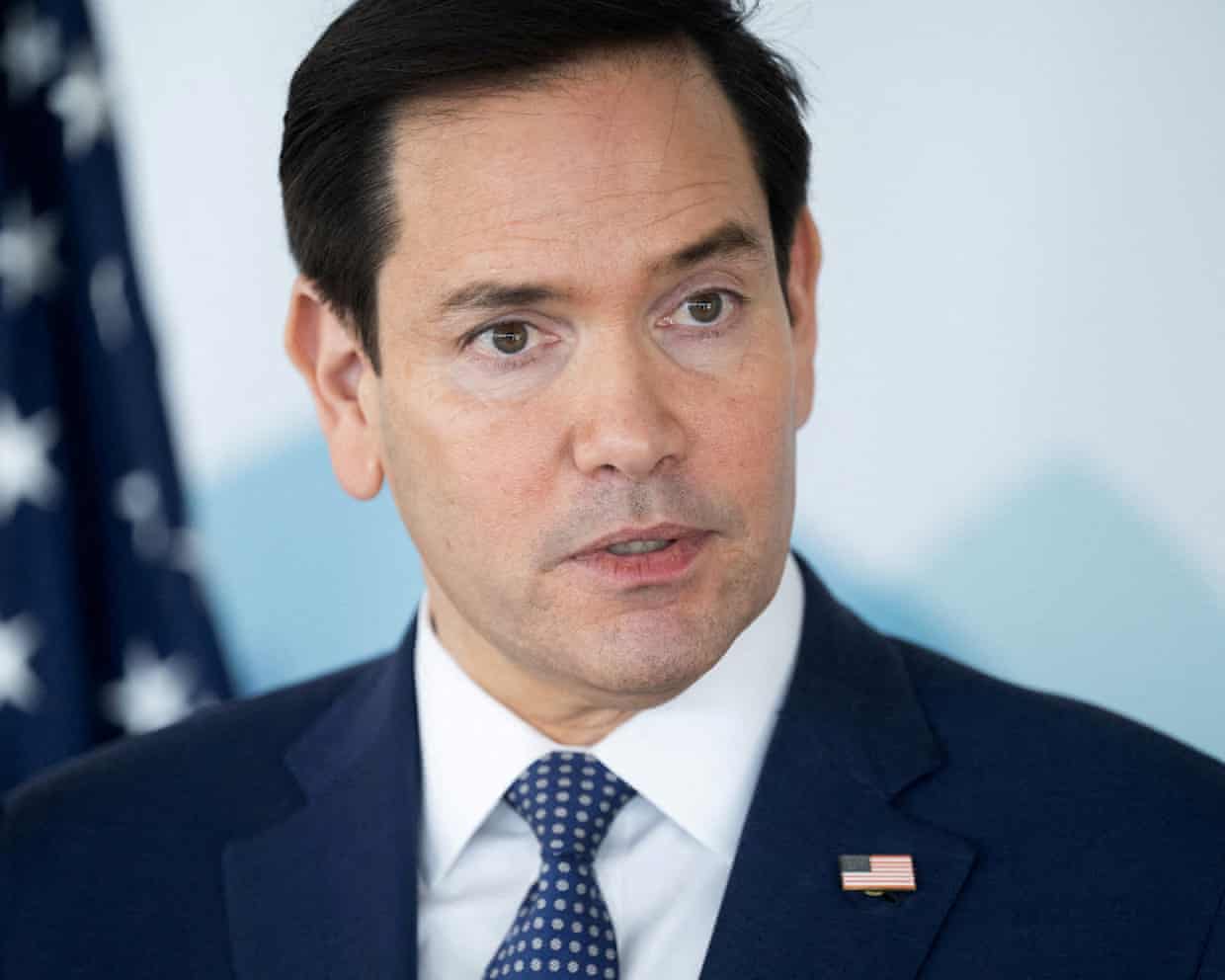 A headshot of the US secretary of state, Marco Rubio, with the US flag behind him