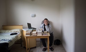 A patient covers his face as he poses in his bedroom at the psychiatric hospital “EPS de Ville Evrard, Centre psychiatrique du Bois de Bondy”.