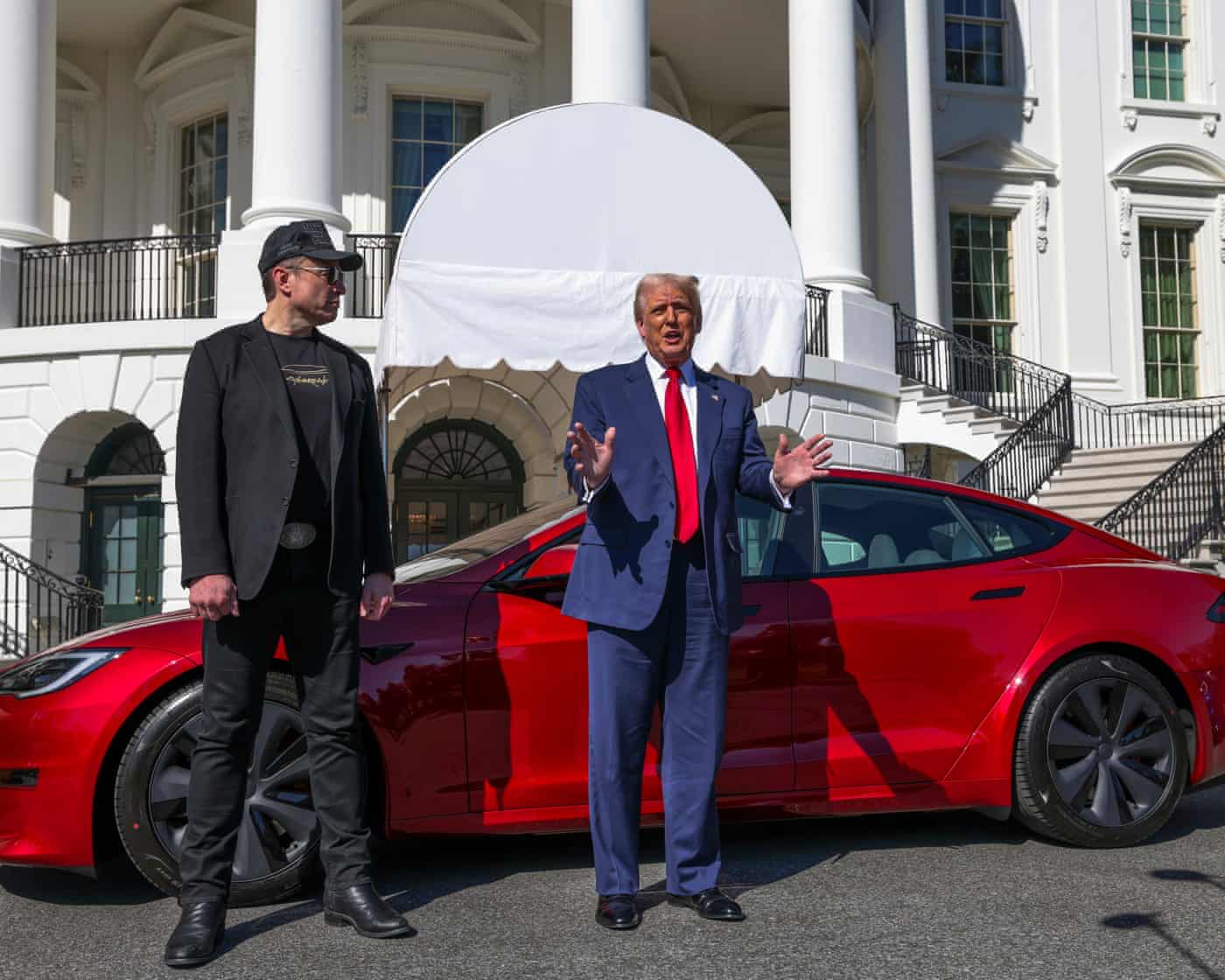 Trump Tesla: Musk Feud & Potential Sale – Live Updates Trump and Musk standing in front of a red Tesla.