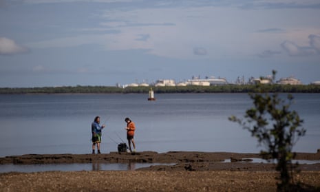 Fishermen try their luck in the Elizabeth River which flows into Darwin Harbour in the Northern Territory, in the background is the Ichthy's gas onshore processing facility on Middle arm