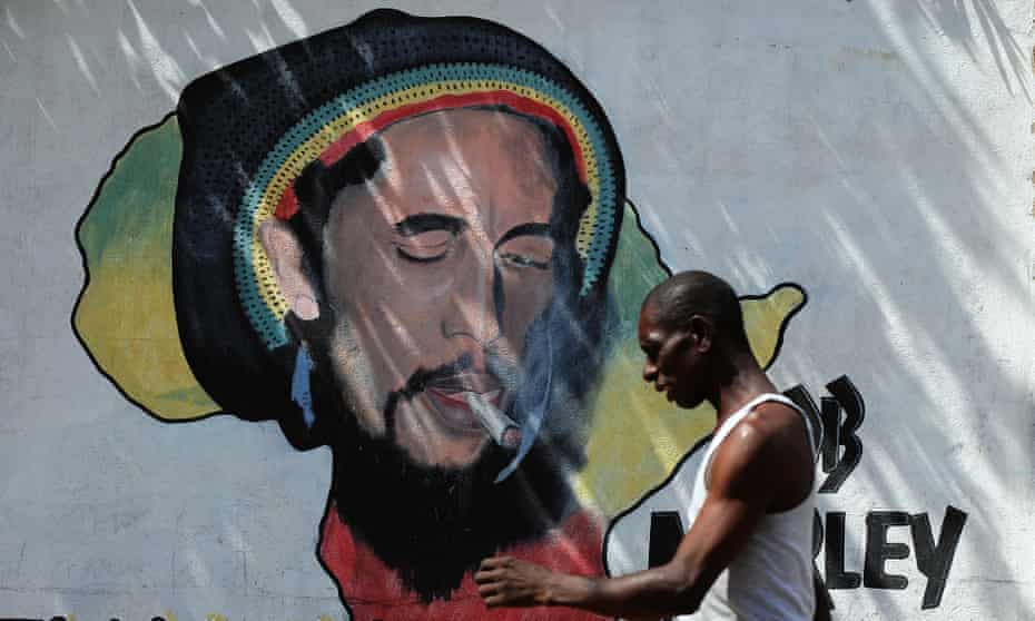 A man walks past a mural of late reggae musician Bob Marley in Kingston.