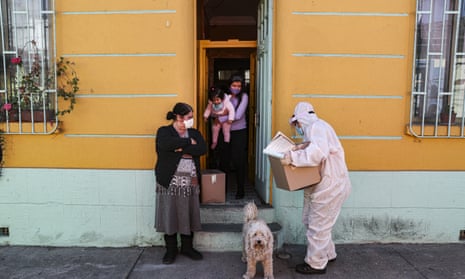 A city worker, dressed in protective gear, delivers a box of food during a mandatory quarantine ordered by the government amid the new coronavirus pandemic in Santiago, Friday, May 22, 2020. (AP Photo/Esteban Felix)