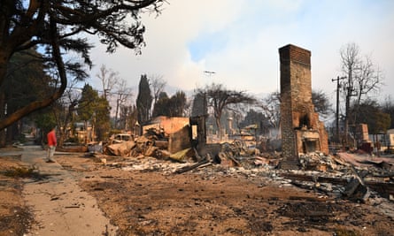 A resident inspects the remains of a home destroyed by fire