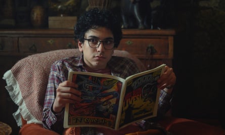 Reading comic in dark room and looking apprehensive