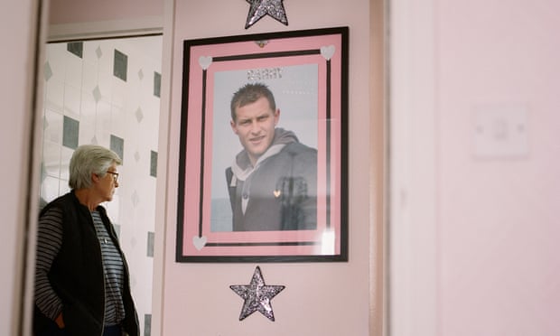 Karen Beadle standing in a doorway at her home near Watford, with a large photograph of her only son, Garry, on the wall