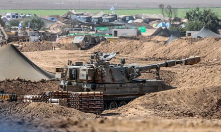 Israeli soldiers in armoured vehicles at an undisclosed location near the border with Gaza on Thursday