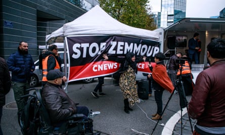 A woman poses in front of a banner reading ‘Stop Zemmour’