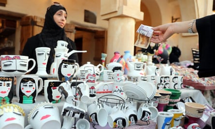 A woman sells painted coffee cups